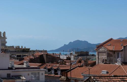 - une vue sur les toits des bâtiments et l'océan dans l'établissement Le Mimosas - Studio Cannes centre - Vue mer Terrasse WIFI climatisation, à Cannes