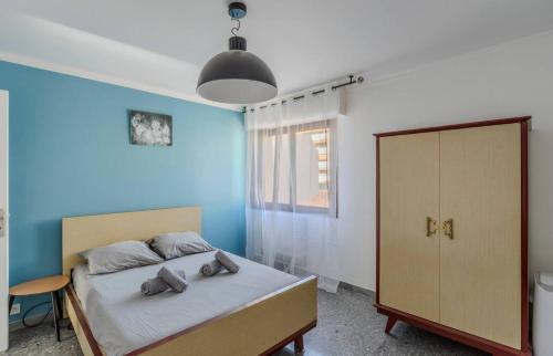 une chambre avec un lit et un mur bleu dans l'établissement Le Saint Paul - 2 chambres - 2 salles de bains - WIFI climatisation, à Cannes