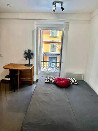une chambre avec un lit, un bureau et une fenêtre dans l'établissement Studio Nice Port BONAPARTE Place du Pin, à Nice