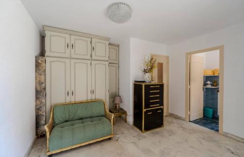 - un salon avec une chaise verte et une commode dans l'établissement Studio Fenelon terrasse et Parking Cannes, à Cannes