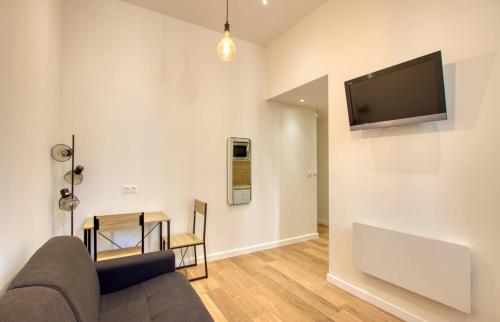 un salon avec un canapé et une télévision sur un mur dans l'établissement Elégant Studio moderne Wifi Proche suquet - LIMESTAY, à Cannes