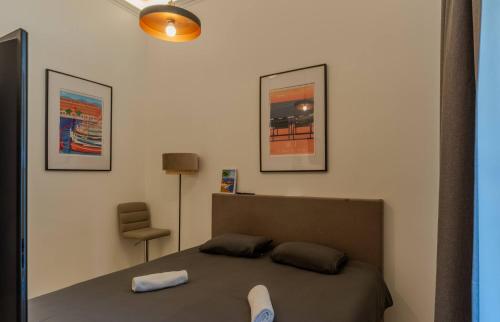 une chambre avec un lit et deux tableaux au mur dans l'établissement Le Lac Studio Moderne Proche Suquet - climatisation Wifi - LIMESTAY, à Cannes
