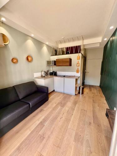 un salon avec un canapé noir et une cuisine dans l'établissement Studio Nice Hyper-centre Jean Médecin, à Nice