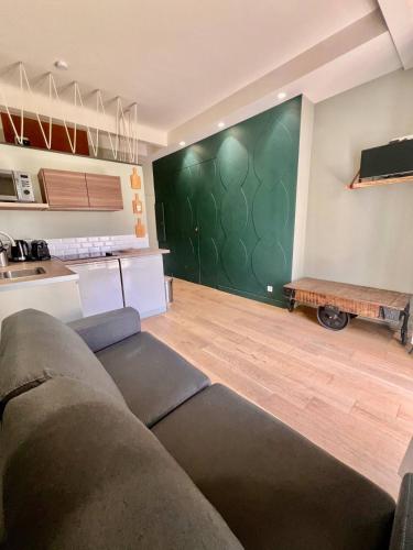 - un salon avec un canapé et un mur vert dans l'établissement Studio Nice Hyper-centre Jean Médecin, à Nice