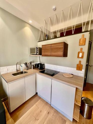 une cuisine avec des armoires blanches et un évier dans l'établissement Studio Nice Hyper-centre Jean Médecin, à Nice