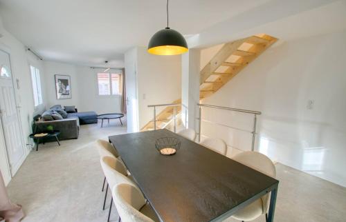 ein Esszimmer mit einem schwarzen Tisch und Stühlen in der Unterkunft Maison Moderne Cannes 3 Chambres 3 Salles de Bain WIFI - LIMESTAY in Cannes