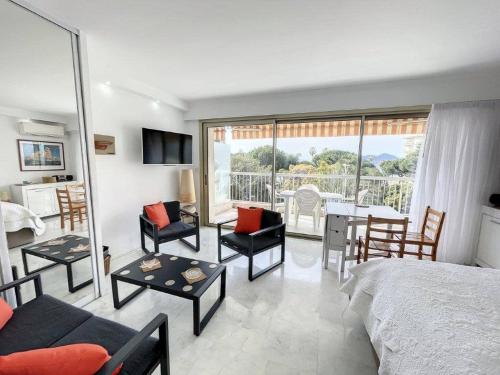 une chambre avec un lit, une table et des chaises dans l'établissement STUDIO MIDI MAGRET Cannes, à Cannes