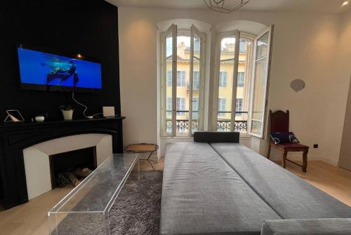 un salon avec une télévision et une cheminée dans l'établissement 2 pièces Hypercentre Gioffredo Nice, à Nice