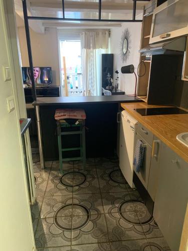 - une petite cuisine avec un comptoir et un tabouret dans l'établissement Petit Studio Confortable, à Clermont-Ferrand