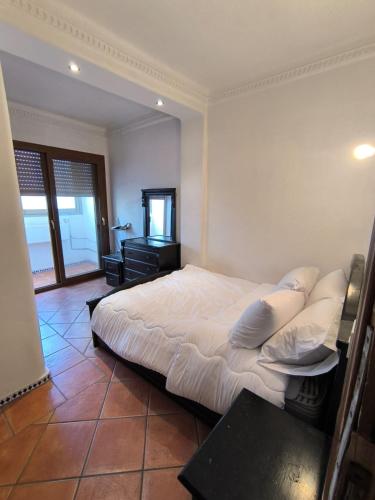 a bedroom with a large white bed and a desk at Cozy Moroccan House in Agadir