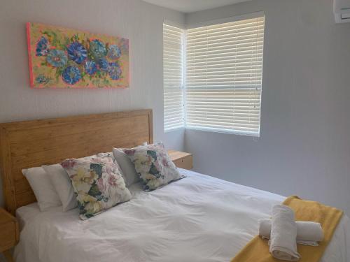 a bedroom with a white bed with pillows and a window at Chaka's Cove 74 in Ballito