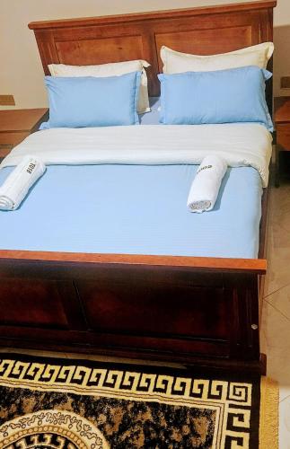 a bed with blue and white pillows on it at Efrona Homes in Kampala