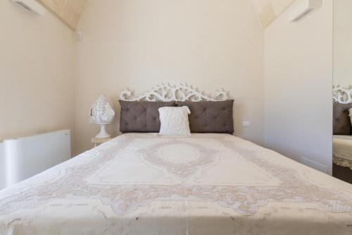 a bedroom with a large bed with a white bedspread at Casale Amenola by Perle di Puglia in Ostuni
