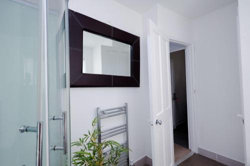 a mirror hanging on a wall next to a door at Hope Deluxe King Bedroom Manchester in Middleton
