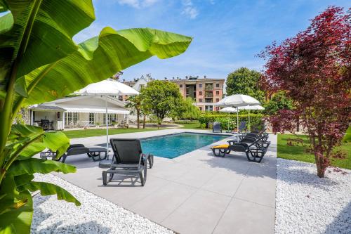 a pool with chairs and umbrellas next to a building at Villa Rachel Quadro in Intra