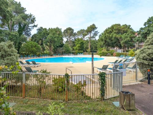 une piscine dans un parc avec une clôture dans l'établissement Le cocon des sables, à Moliets-et-Maa