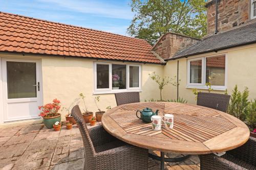 a wooden table and chairs on a patio at Newton House - North East Escapes in Newton by the Sea