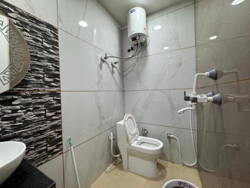 a bathroom with a toilet and a sink at Hotel Guruvayur Dham in Mathura