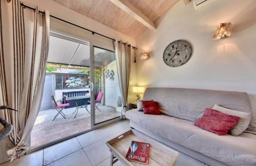 un salon avec un canapé et une horloge au mur dans l'établissement 110 L'Annexe Cute house, à Saint-Martin-de-Ré