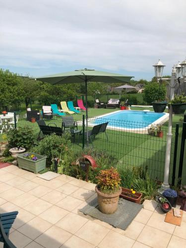 une clôture avec un parasol et une piscine dans l'établissement Petite Gaudiniere, à La Chapelle-Gauguin