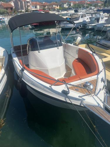 um barco com um assento laranja sentado na água em Speedboat Tours Our Lady Of The Rocks, Perast, Mamula Island and Blue Cave swiming em Tivat