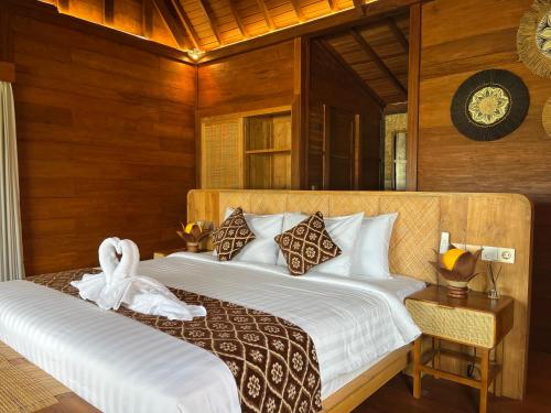 a bedroom with two beds and a clock on the wall at Villa Gong bali in Ubud