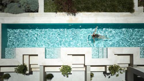 a person is swimming in a swimming pool at El Vicenç de la Mar - Adults Only - Over 12 in Pollença
