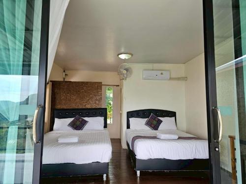 a bedroom with two beds and a window at Doymoktawanview ดอยหมอกตะวันวิว in Ban Yang Di Pha Mop