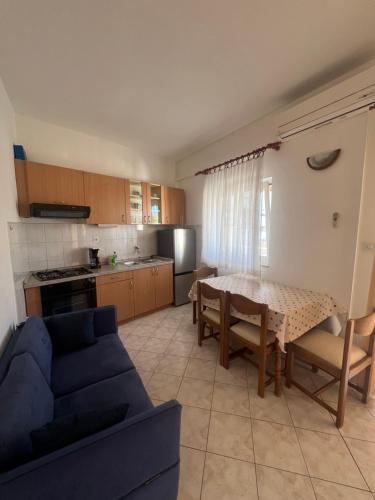 a living room with a table and a blue couch at Sunce Mobile Homes & apartments in Grebaštica