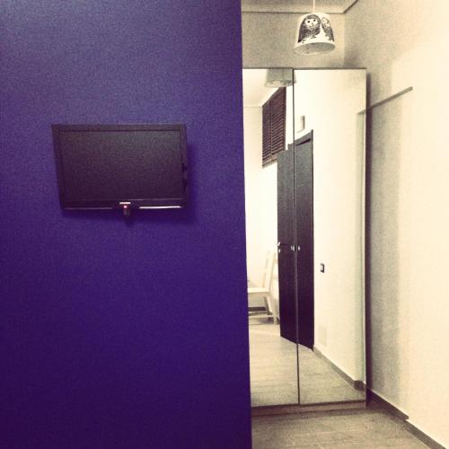 a room with a purple wall with a television on it at Casa Santiago in Gela