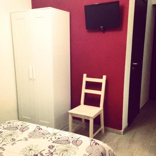 a bedroom with a bed and a chair and a tv at Casa Santiago in Gela