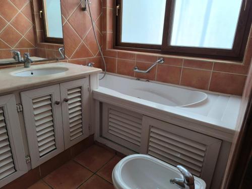a bathroom with a tub and a sink and a toilet at Cozy Moroccan House in Agadir