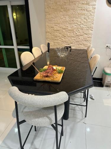 a black dining room table with a plate of food at Villa James in Tarlac