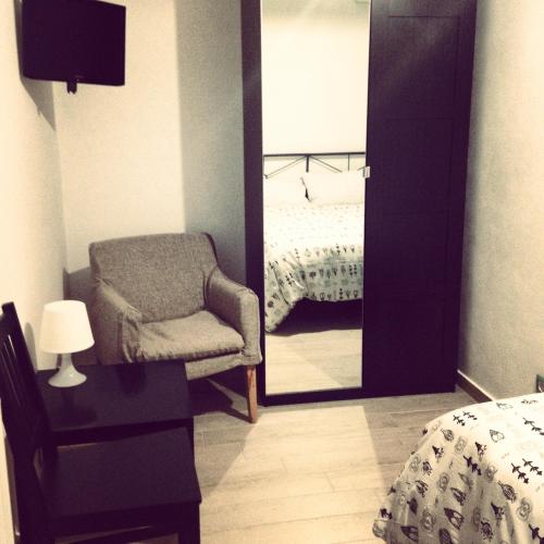 a bedroom with a mirror and a chair and a bed at Casa Santiago in Gela