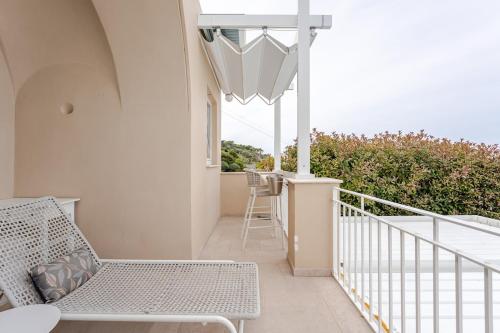 a balcony with a bench and a table and chairs at Villa DAlessandro in Anacapri