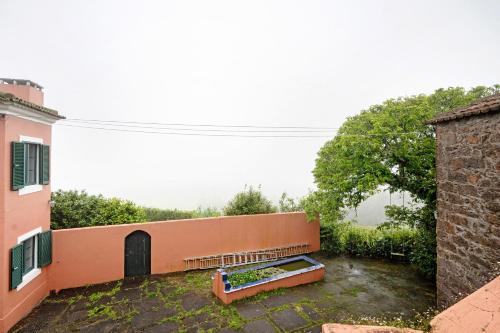 a bench in a yard next to a building at Quinta das Queimadas in Nordeste