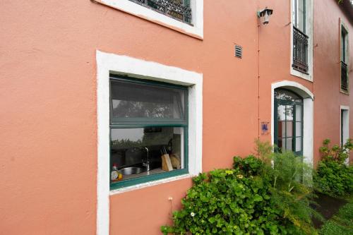 a window of a pink building with a sink at Quinta das Queimadas in Nordeste