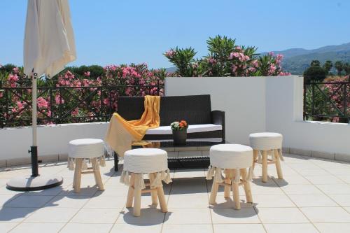 a patio with a bench and stools on a balcony at Villa Aphrodity in Kos Town