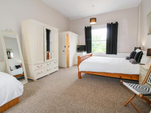 a large bedroom with two beds and a tv at The Laurels in Bishops Castle