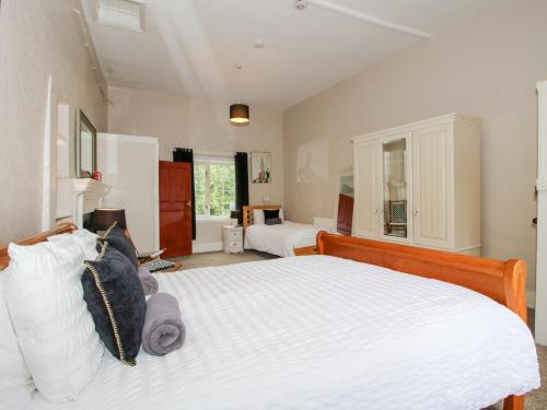 a bedroom with a large bed with white sheets at The Laurels in Bishops Castle