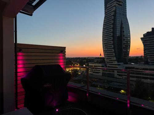 a balcony with a view of a city at sunset at Luxury Penthouse Rzeszów in Rzeszów