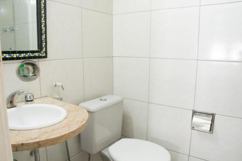 a white bathroom with a sink and a toilet at Infinity Copacabana in Rio de Janeiro