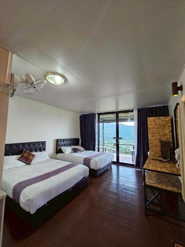 a hotel room with two beds and a balcony at Doymoktawanview ดอยหมอกตะวันวิว in Ban Yang Di Pha Mop