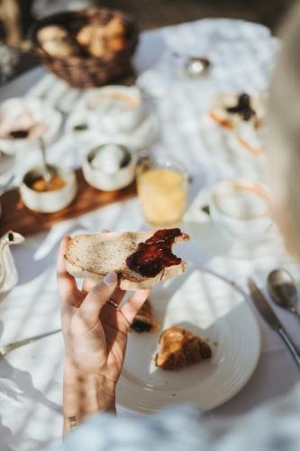a person holding a piece of food on a table at Hotel KÜGLERHOF in Tirolo