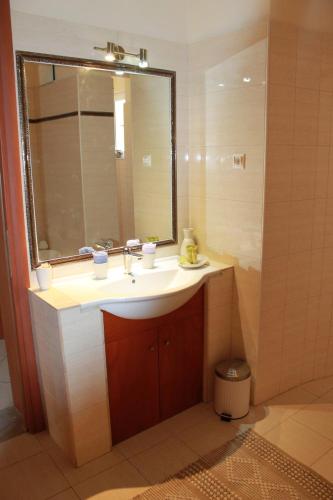a bathroom with a sink and a mirror at Villa Aphrodity in Kos Town