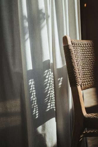 a chair is sitting in front of a window at Hotel KÜGLERHOF in Tirolo