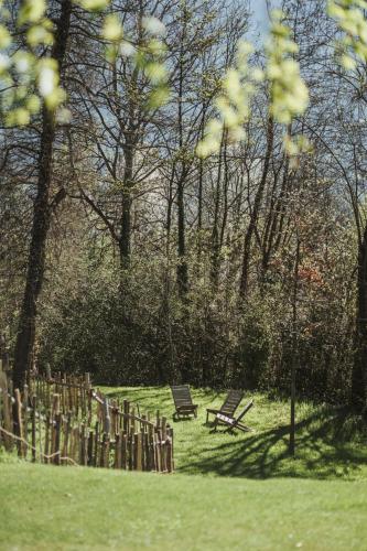 two benches in a park with a fence and trees at Hotel KÜGLERHOF in Tirolo