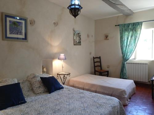 una camera da letto con due letti e una finestra di Le Mas des Baux a Bédoin