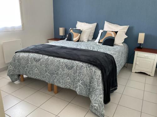 - un lit avec une couverture noire et des oreillers dans l'établissement La Maison des Roses, à Longeville-sur-Mer