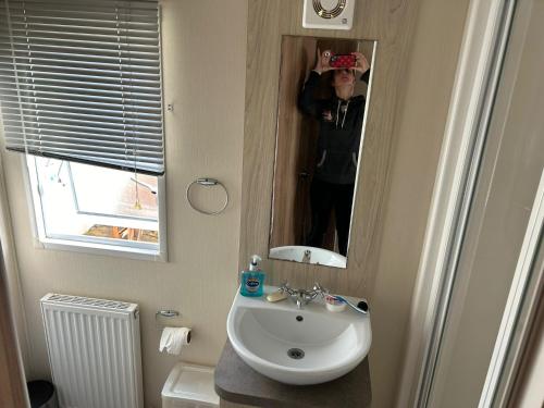 een persoon die een foto neemt van een badkamerspiegel bij Ardmachree in Burton Bradstock
